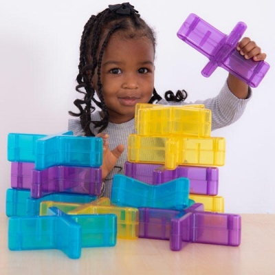 Criança a brincar com blocos de construção coloridos translúcidos.