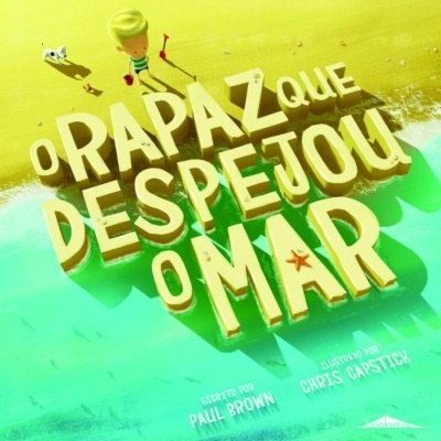 Capa de livro com título em letras 3D amarelas na praia junto ao mar.