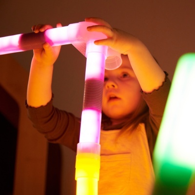 Criança a brincar com blocos luminosos de plástico coloridos