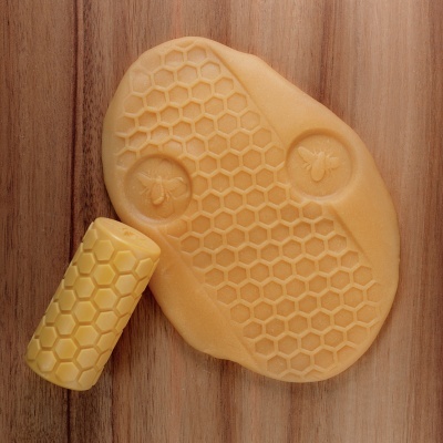 Produtos amarelos com padrão de favo de mel sobre madeira