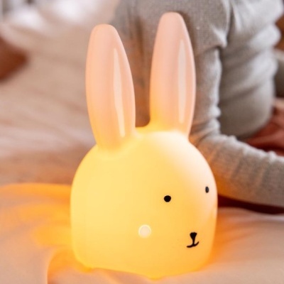Lâmpada em forma de coelho amarela com olhos e nariz pretos