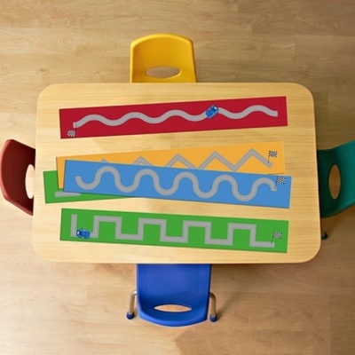 Mesa com quatro cadeiras coloridas e quatro tapetes com pistas de corrida e carros de brinquedo azuis