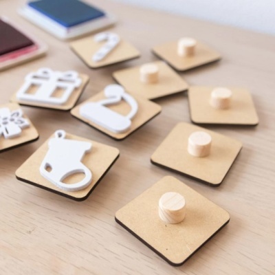 Pendentes decorativos em madeira com formas brancas sobre mesa clara