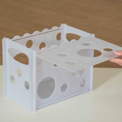 Caixa organizadora quadrada branca de plástico translúcido com aberturas redondas e tampa removível.