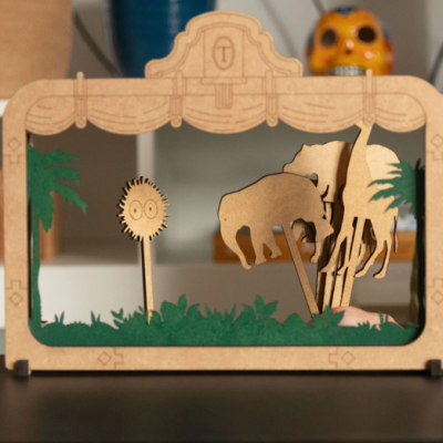 Miniatura de MDF com elefante, girafa, palmeiras e flor em cena de savana africana