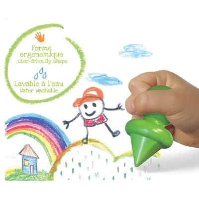 Mão infantil segurando giz de cera verde desenhando em papel com desenhos coloridos