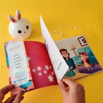 Livro infantil aberto com ilustrações em fundo amarelo e abajur coelho ao lado