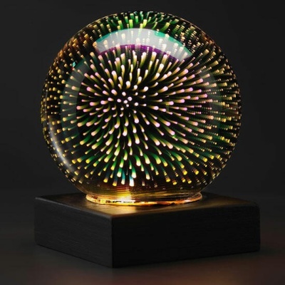 Globo de vidro com luzes coloridas numa base preta