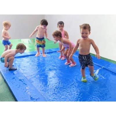 Tapete de água infantil azul com crianças a brincar