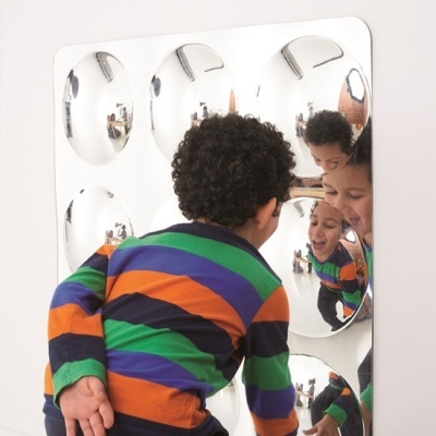 Painel de espelhos redondos refletindo uma criança com camisola colorida