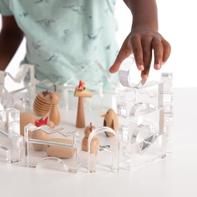 Conjunto de blocos de construção transparentes e figuras de madeira com criança a brincar