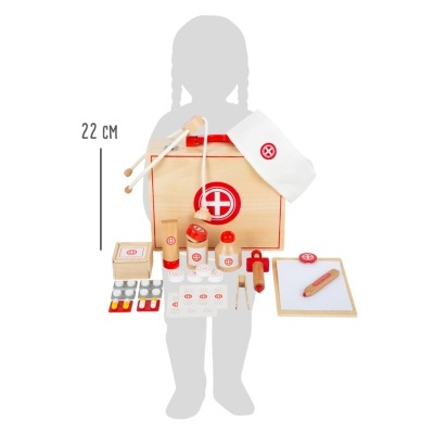 Brinquedo médico de madeira com vários acessórios e caixa com símbolo vermelho.