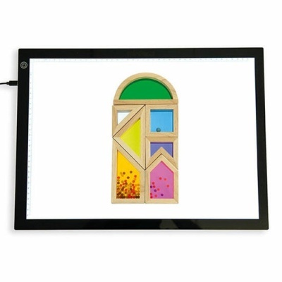 Mesa de luz digital com formas geométricas de madeira coloridas em cima.