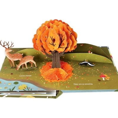 Livro infantil pop-up com cena de floresta, animais e árvore laranja