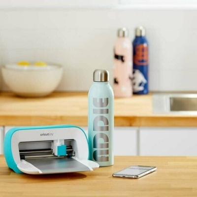 Mesa de cozinha com mini plotter, garrafa térmica ADDIC e smartphone
