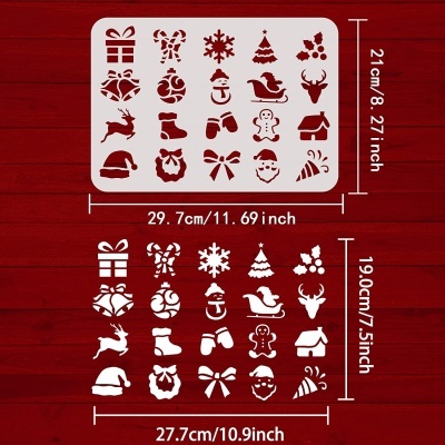 Stencils de plástico branco com desenhos de Natal sobre fundo vermelho de madeira