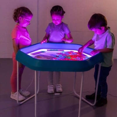 Crianças a usar mesa de atividades iluminada hexagonal azul