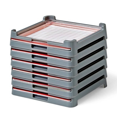 Conjunto de caixas empilhadas com tampas transparentes e folhas quadriculadas.