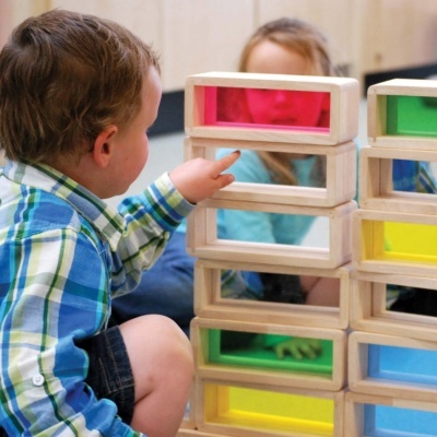 Criança a brincar com blocos coloridos de construção de madeira