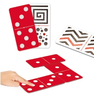 Conjunto de dominós vermelhos e brancos com padrões em uso, mão humana a colocar uma peça