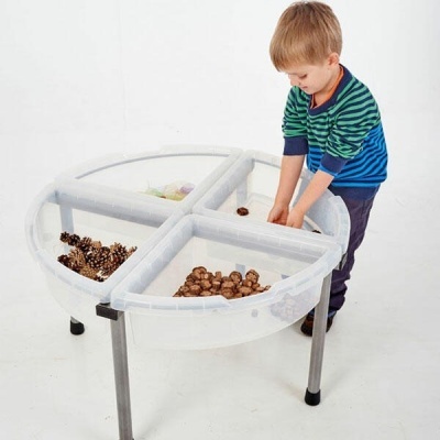 Mesa transparente redonda dividida em quatro com criança a brincar