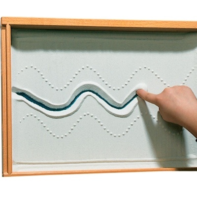 Tabuleiro de madeira com areia cinzenta e linhas onduladas em relevo e mão a tocar