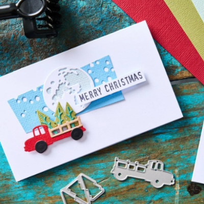 Cartão de Natal artesanal com camião vermelho e árvores verdes, texto Merry Christmas em fundo branco