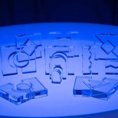 Peças decorativas transparentes em acrílico com formas geométricas em relevo sobre superfície azul