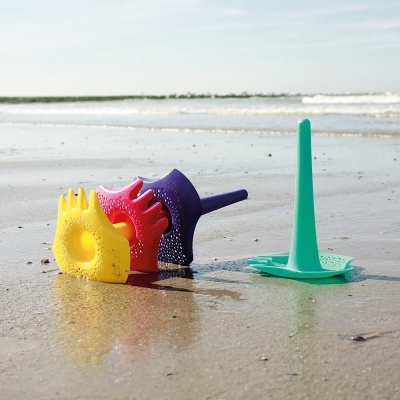 Brinquedos de areia coloridos na praia sobre areia molhada