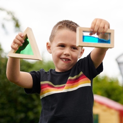 Criança com juguetes em madeira coloridos ao ar livre