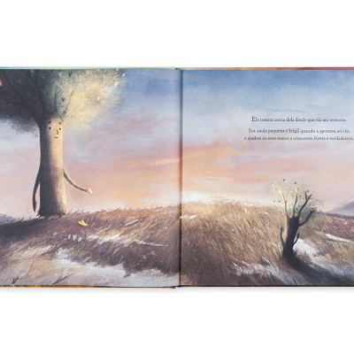Livro infantil aberto com ilustração de duas árvores num campo e texto em português