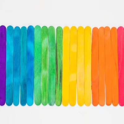 Pauzinhos de madeira coloridos alinhados em várias cores sobre fundo branco