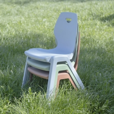 Três cadeiras coloridas empilhadas na relva