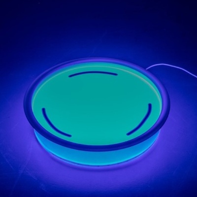 Prato redondo iluminado em azul e verde com detalhes pretos