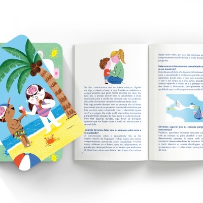 Livro infantil aberto com texto e ilustrações e baralho de cartas coloridas ao lado.