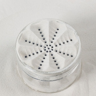 Frasco de vidro com tampa branca perfurada com padrão circular