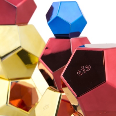 Objetos geométricos metálicos coloridos com acabamento espelhado e símbolo RXS