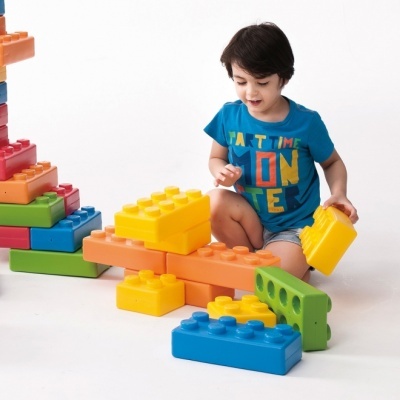 Criança a brincar com blocos de construção coloridos grandes.