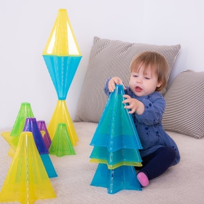 Criança a brincar com brinquedos coloridos de plástico em forma de árvores triangulares