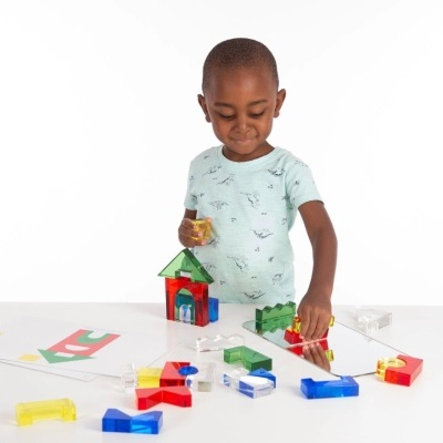 Criança a brincar com blocos de construção coloridos sobre mesa branca