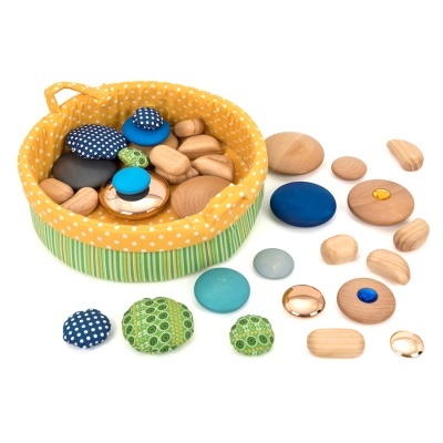 Cesto amarelo com bolinhas brancas com peças de madeira redondas e ovais azuis, verdes e naturais