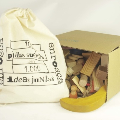 Saco de tecido com texto e caixa de cartão com peças de madeira coloridas