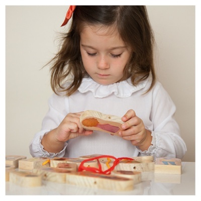 Criança a brincar com blocos de madeira coloridos