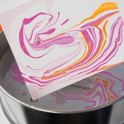 Folha com padrão abstrato em rosa, laranja e branco criada por técnica de pintura em água