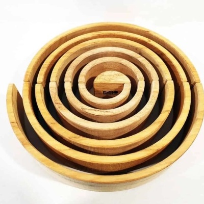 Conjunto concêntrico de formas circulares em madeira clara sobre fundo branco