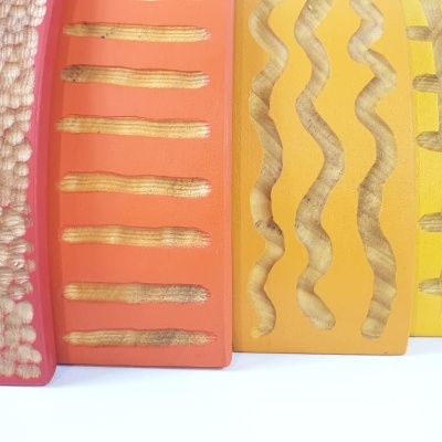 Quatro peças de cerâmica coloridas com texturas e padrões em relevo.