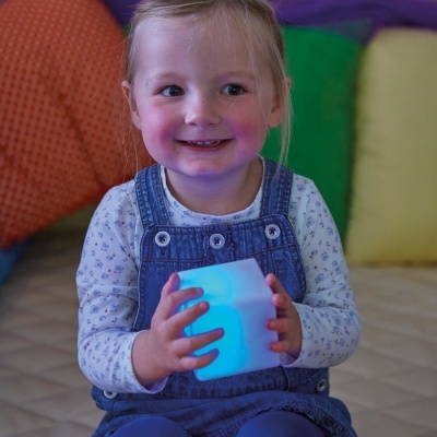 Criança com cubo luminoso azul sentada