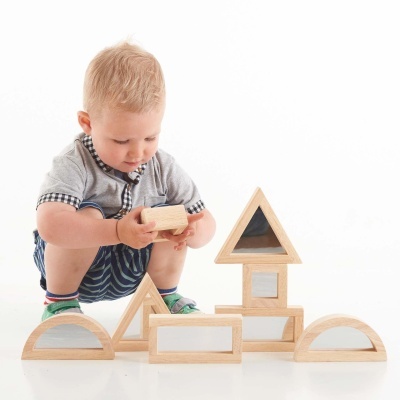 Criança a brincar com blocos de construção de madeira branca e clara