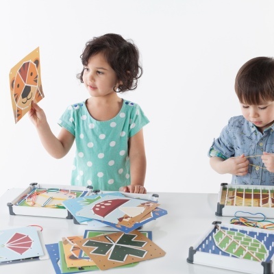 Crianças a brincar com brinquedos de madeira e cartões coloridos com padrões geométricos e animais