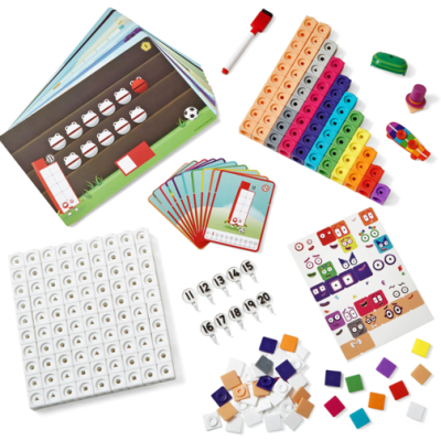 Jogo educativo com peças coloridas, cartões e acessórios sobre superfície branca.